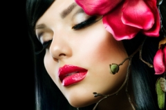 Fashion Brunette Girl with Magnolia Flower isolated on Black