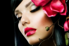 Fashion Brunette Girl with Magnolia Flower isolated on Black